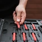 Person selects screwdriver from toolbox.
